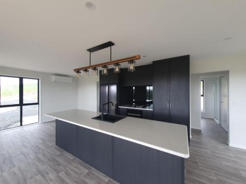 kitchen with black birchwood ply cupboards & Laminex pietra cloud natural finish