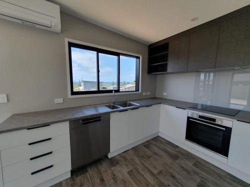 Kitchen doors and panels in Meltecca Snowdrift Finish Woodgrain. Benchtop Laminex 30mm Grigio Grafite square edge